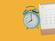 Türkiser Wecker und Kalender mit Juli-Monat auf gelbem Hintergrund – Symbolbild für rechtzeitige Planung und Vorbuchung auf dem Traumpfad München–Venedig