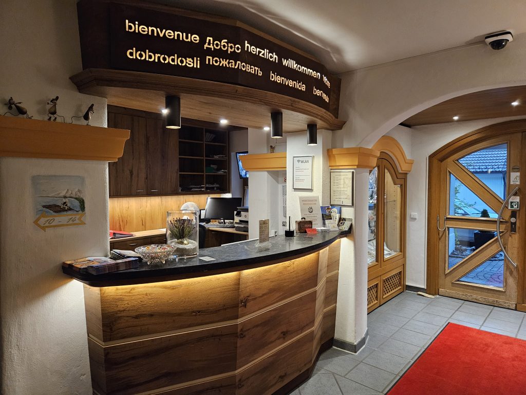 Rezeption des Isartaler Hofs mit Willkommensschild in mehreren Sprachen