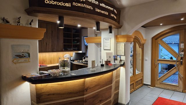 Rezeption des Isartaler Hofs mit Willkommensschild in mehreren Sprachen