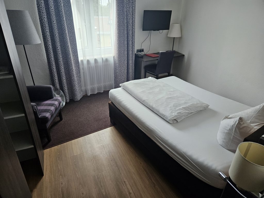 Einzelzimmer mit Schreibtisch und Fernseher im Posthotel Kolberbräu