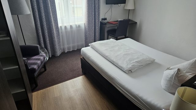 Einzelzimmer mit Schreibtisch und Fernseher im Posthotel Kolberbräu