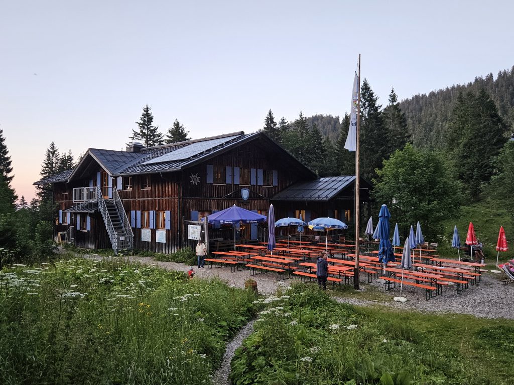 Tutzinger Hütte mit Biergarten im Abendlicht und Solarpanelen