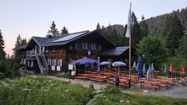 Tutzinger Hütte mit Biergarten im Abendlicht und Solarpanelen