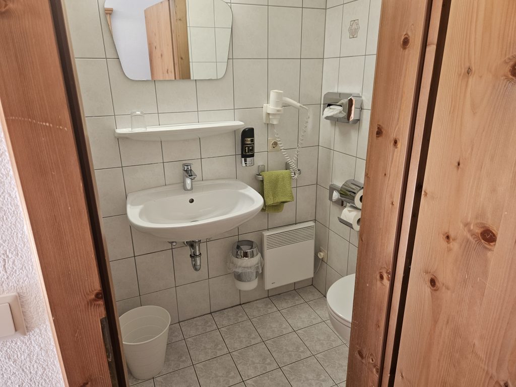 Badezimmer mit Dusche und Haartrockner im Gasthof zur Post Hinterriss