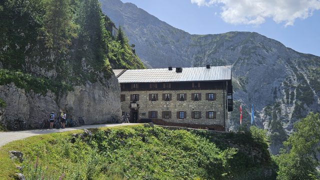 Karwendelhaus auf Felsvorsprung mit Bergkulisse