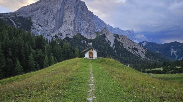 Kleine Bergkapelle auf einer Wiese vor der beeindruckenden Lafatscher Nordwand bei der Hallerangeralm