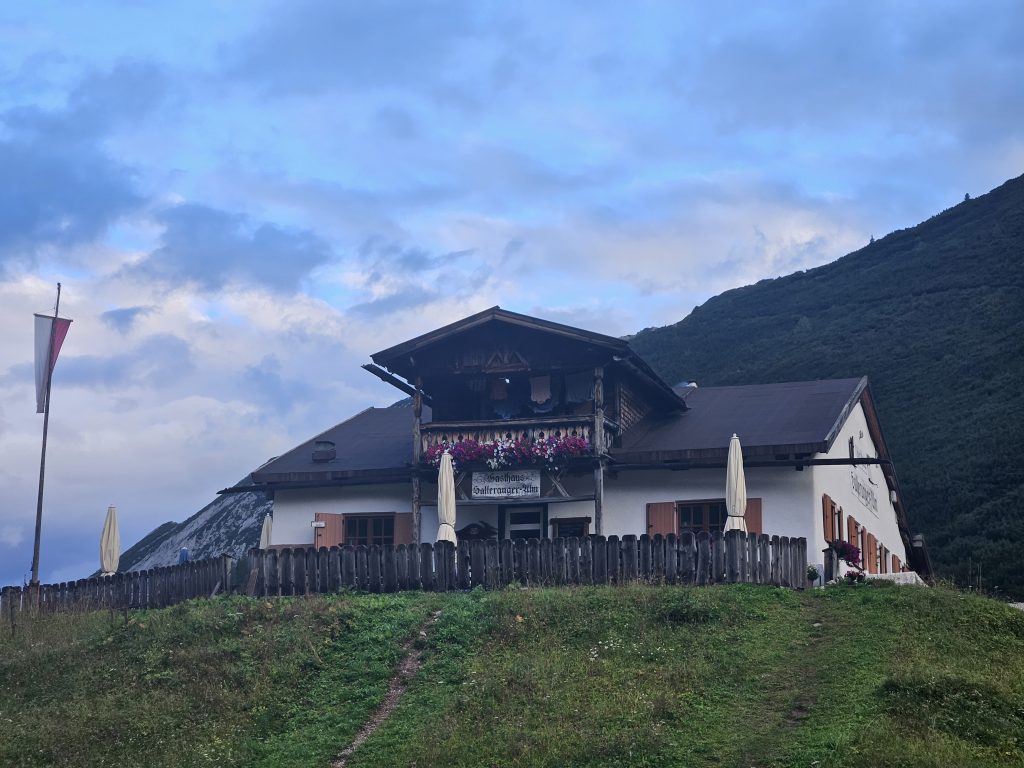 Hallerangeralm mit Holzterrasse und Sonnenschirmen, gelegen auf einer kleinen Anhöhe im Karwendel