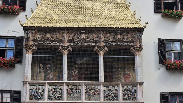 Detailaufnahme des Goldenen Dachls mit goldenen Schindeln und Wandmalereien in Innsbruck