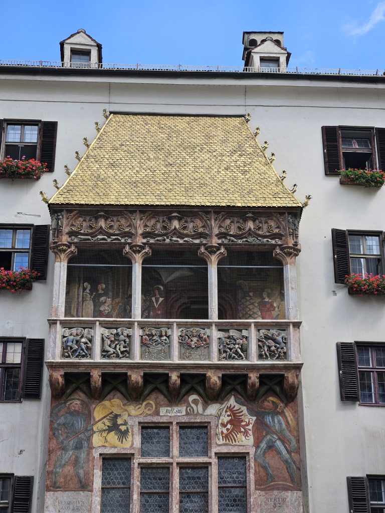 Detailaufnahme des Goldenen Dachls mit goldenen Schindeln und Wandmalereien in Innsbruck