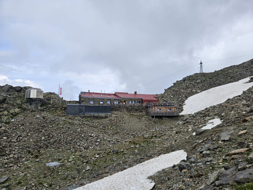 Glungezerhütte auf karger Hochgebirgskuppe mit umliegenden Felsen