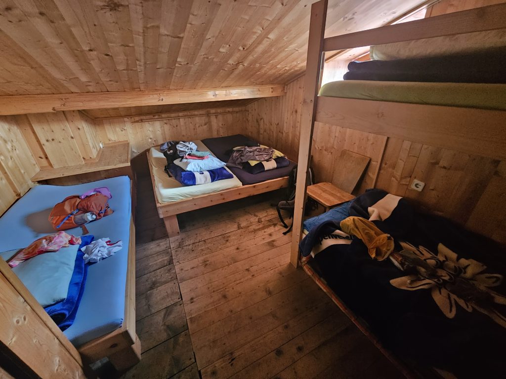 Kleines Mehrbettzimmer mit Holzbetten und schräger Decke