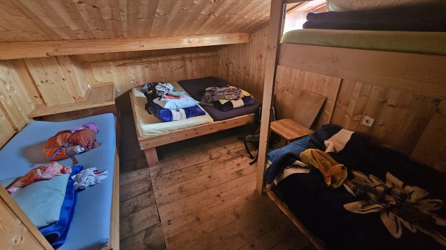 Kleines Mehrbettzimmer mit Holzbetten und schräger Decke