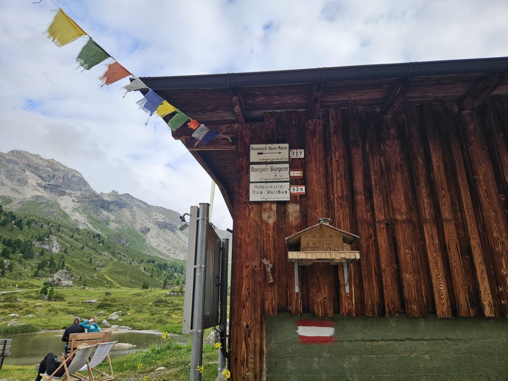 Wanderwegweiser an der Lizumer Hütte mit Wegmarkierungen und Blick auf die Berge