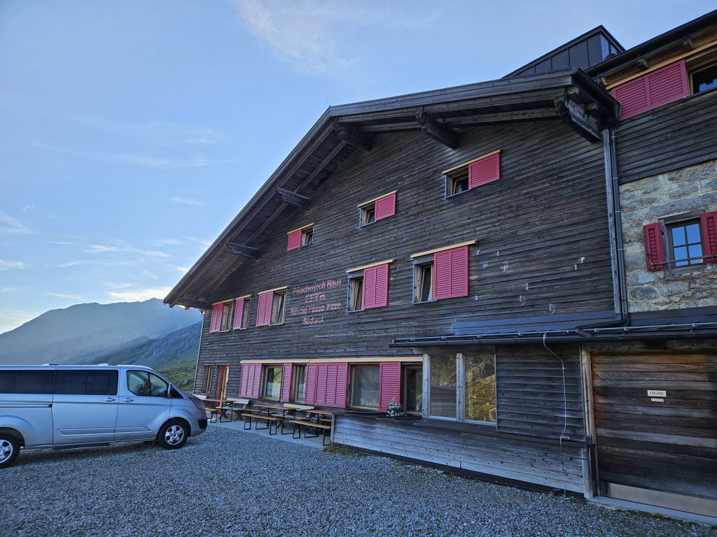 Außenansicht des Pfitscherjoch Hauses mit pinken Fensterläden