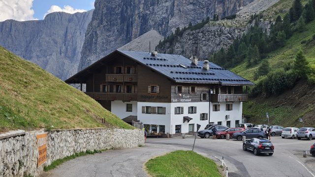 Rifugio Frara am Grödner Joch mit steilen Dolomitwänden im Hintergrund
