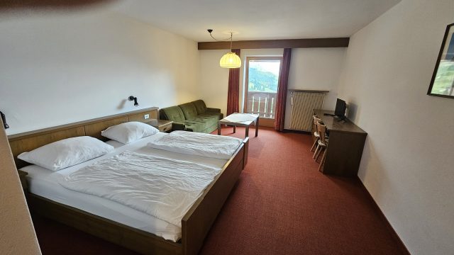 Großes Doppelzimmer im Rifugio Frara mit Couch, Tisch und Balkon