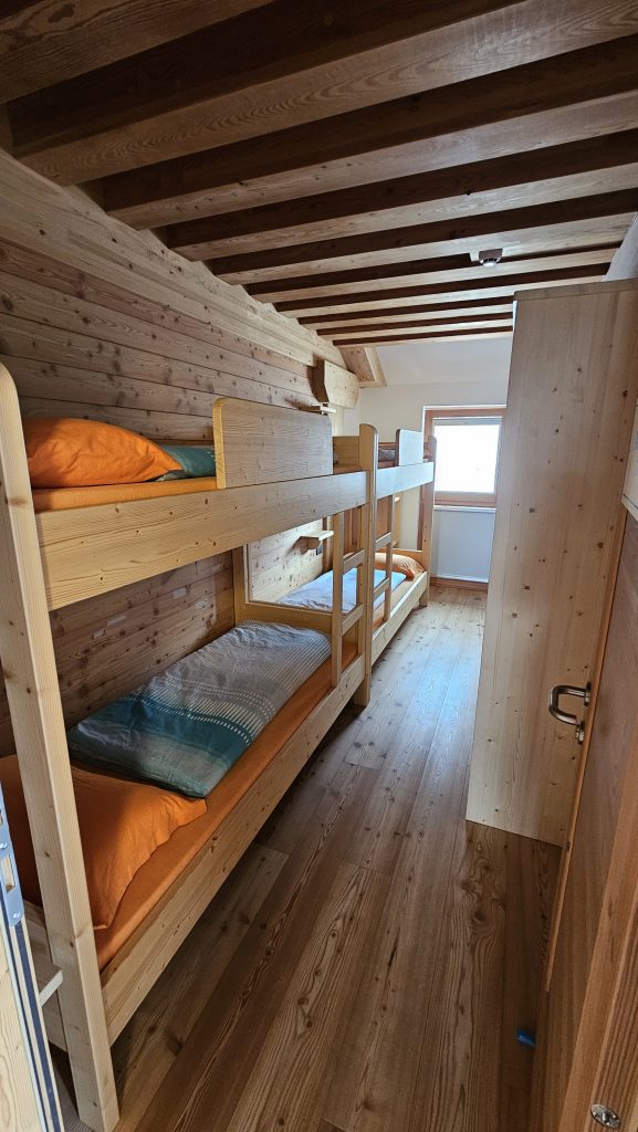 Schlafraum mit Holzstockbetten in Rifugio Boè