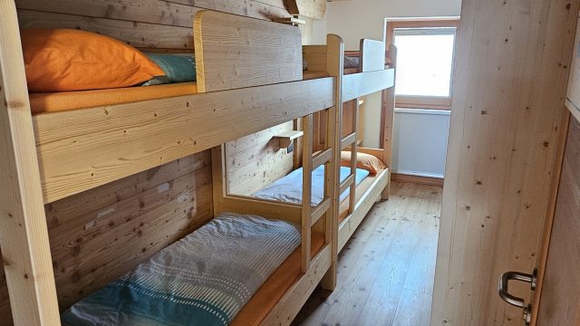 Schlafraum mit Holzstockbetten in Rifugio Boè