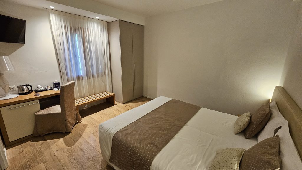 Modernes Hotelzimmer mit Schreibtisch und Doppelbett im Hotel Da Tullio