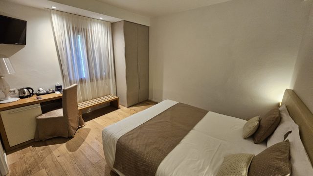 Modernes Hotelzimmer mit Schreibtisch und Doppelbett im Hotel Da Tullio