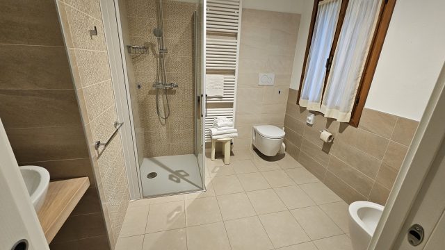 Geräumiges Badezimmer mit Dusche und WC im Hotel Da Tullio